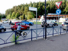 Chi te lo fa fare? Una persona in bicicletta accanto alle automobili in una rotatoria dell’Aquila.